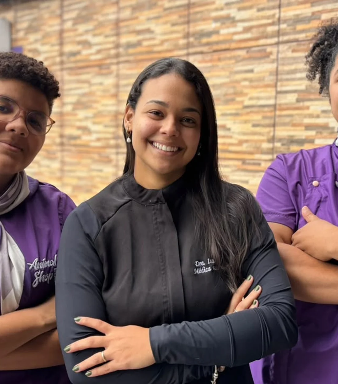 Integrantes da equipe Animal Shop sorrindo, de uniforme, dentro da loja